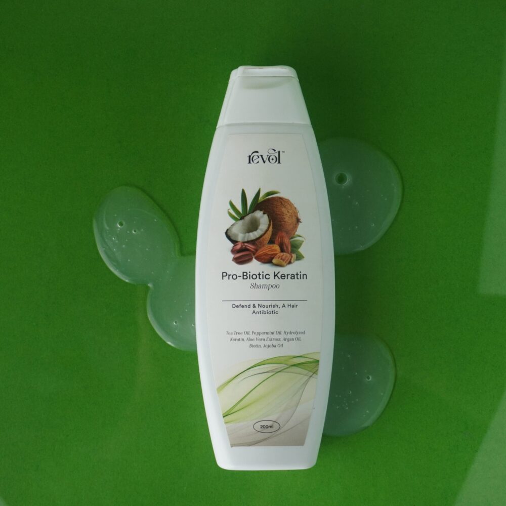 Revol Pro-Biotic Keratin Shampoo bottle on green background - clarifying shampoo from a Pakistani brand.