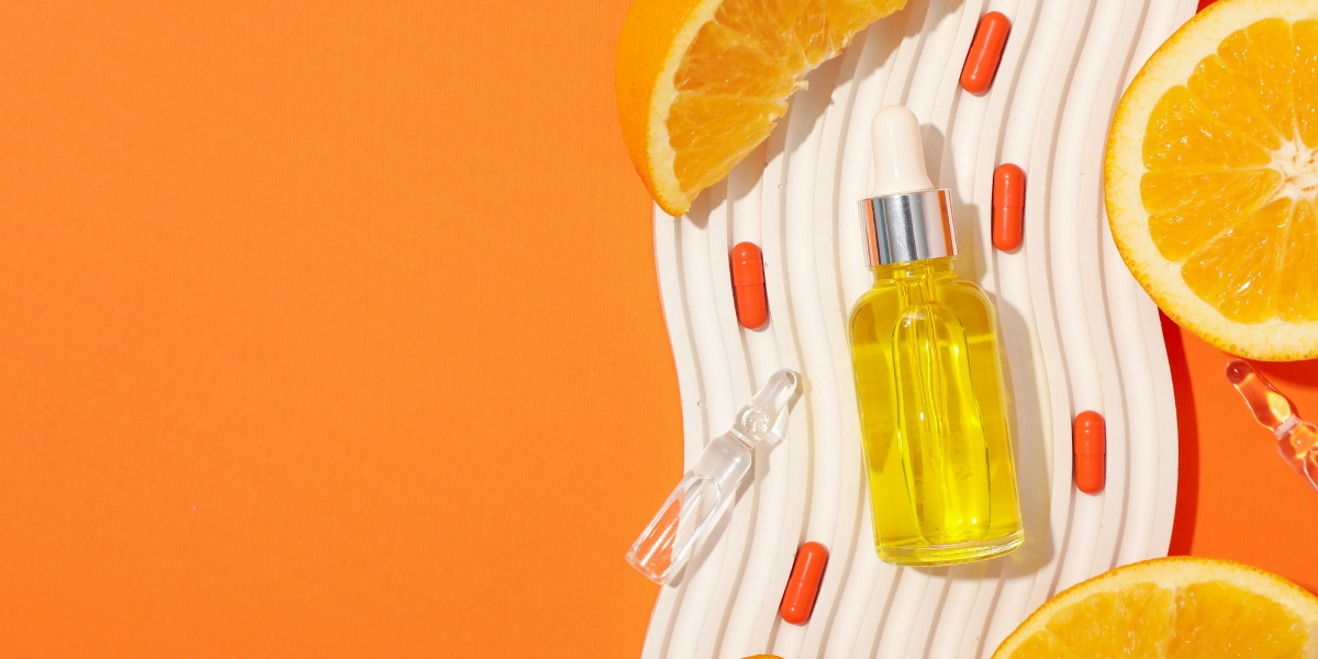 a bottle of oil next to a slice of orange