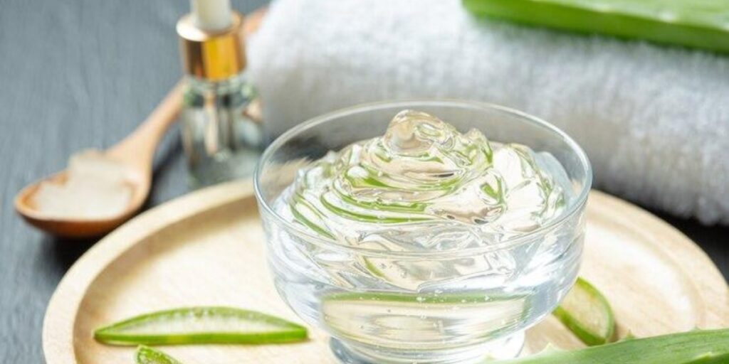 Aloe vera gel in a glass bowl with aloe leaves, perfect for glowing skin and treating dead skin.