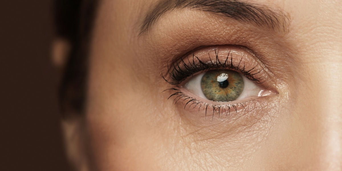 Close-up of an eye showing fine lines and wrinkles under eyes, highlighting a natural look.